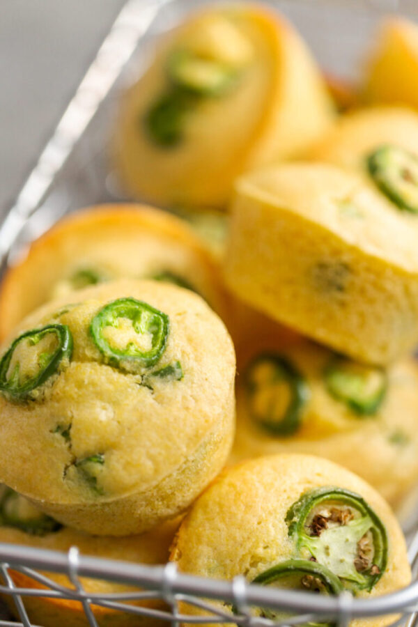 Freshly baked cornbread muffins with spicy jalapeno pepper in wired basket.