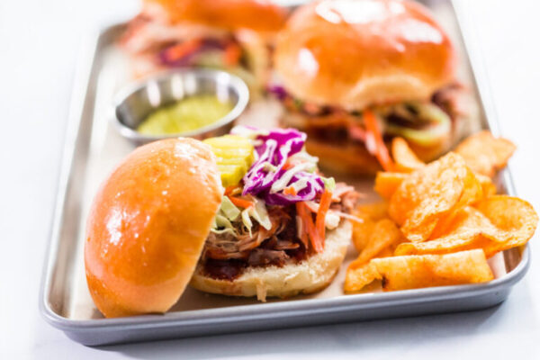 BBQ pulled pork sandwich in shape of small sliders with brioche buns.