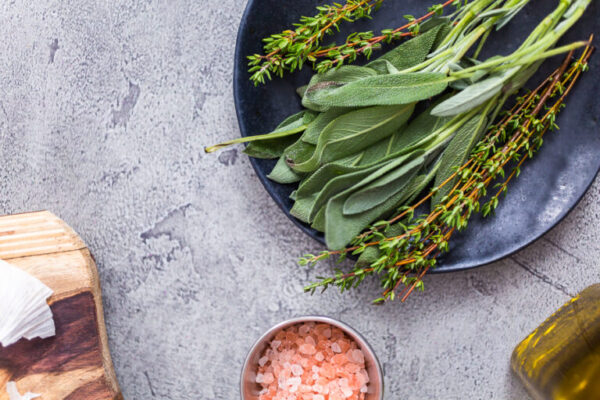 Fresh rosemary and sage spices on a black plate from the local organic garden.