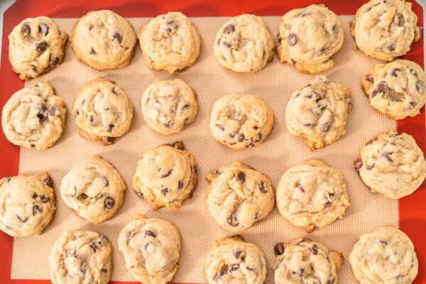 Freshly baked homemade soft chocolate chip cookies on a baking sheet.