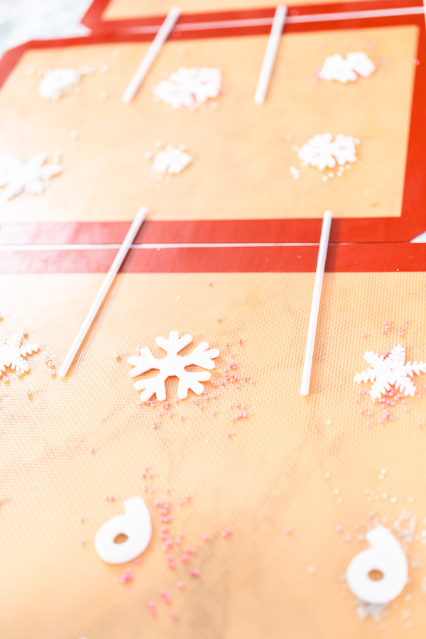 Making homemade berry flavor lollipops with snowflakes.