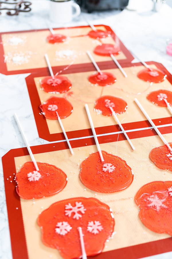 Making homemade berry flavor lollipops with snowflakes.