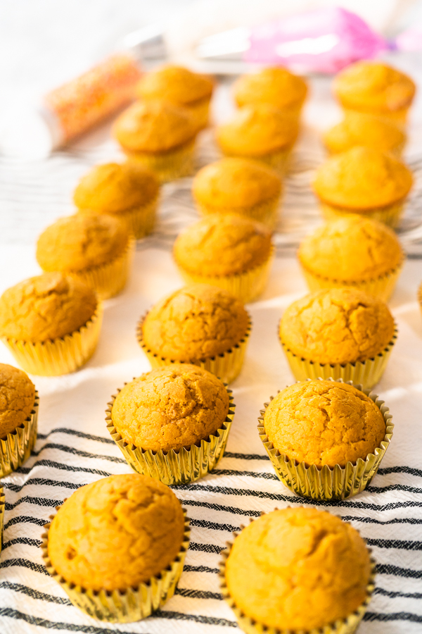 Freshly baked pumpkin spice cupcake cooling on kitchen towel.