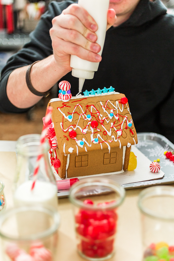 Kids decorating small gingerbread houses at the Christmas craft party.