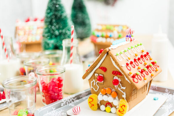 Kids decorating small gingerbread houses at the Christmas craft party.