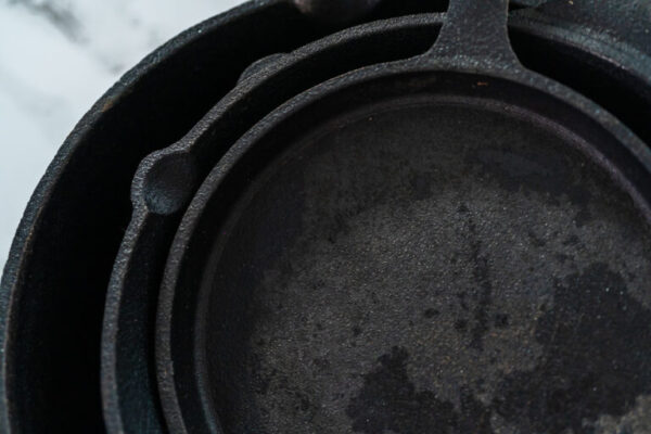 Cast iron frying pan - Arina Photography Close up view. Variety of cast iron frying pans on a marble background.