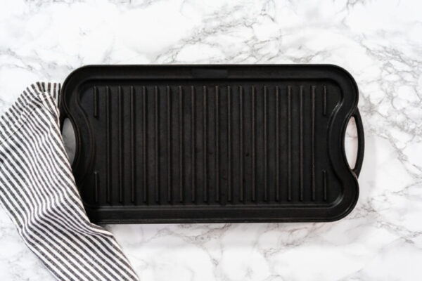 Cast iron griddle - Arina Photography Flat lay. Cast iron griddle on a marble background.