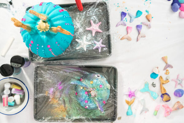 Flat lay. Decorating Halloween craft pumpkins in mermaid theme.