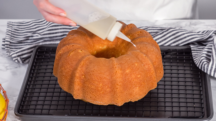Evenly coating a bundt cake with cake syrup for added moisture and flavor.