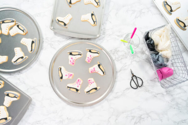 Flat lay. Decorating sugar cookies shaped as figure skates with royal icing.