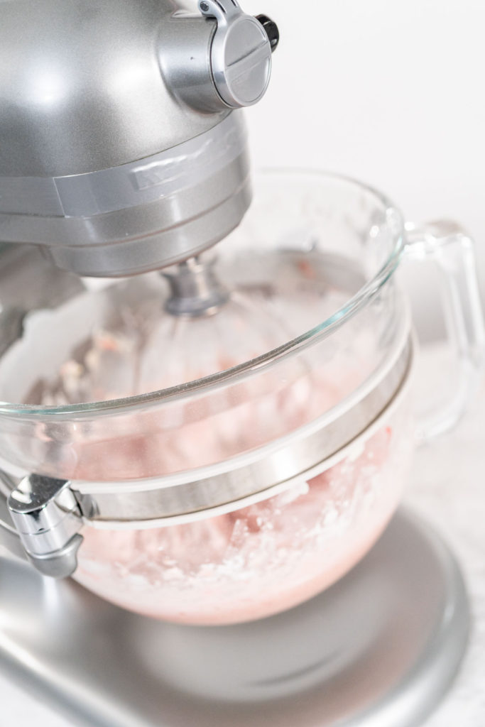 Mixing the full batch of strawberry frosting in the stand mixer until smoo