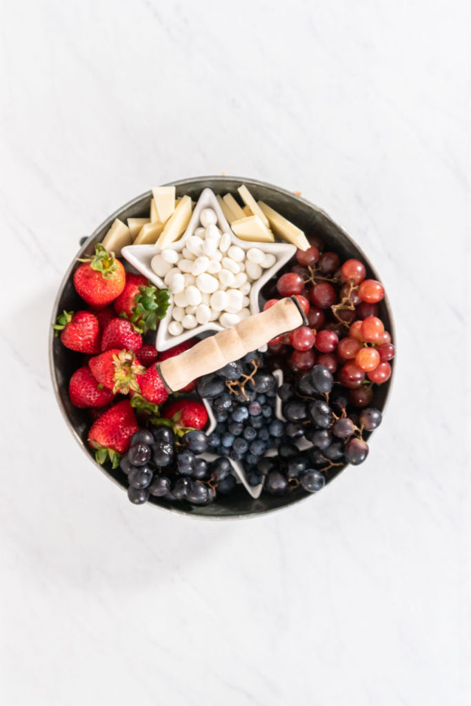 Strawberries and blueberries nestled around snack bowls on the upper tie