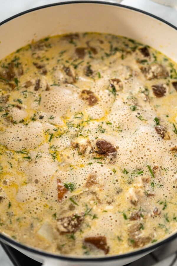 Cooking creamy wild mushroom soup made in an enameled dutch oven.