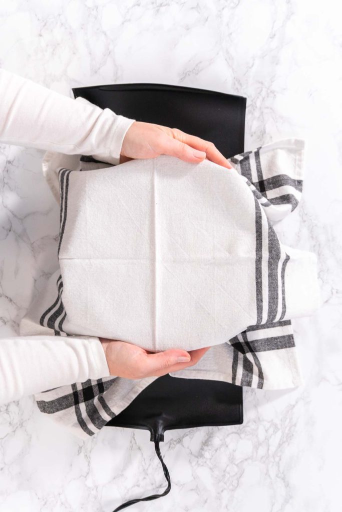 Covering dough bowl with kitchen towel for rising.