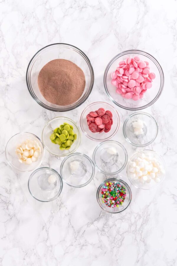 Measured ingredients in a glass mixing bowl to prepare hot chocolate bombs.