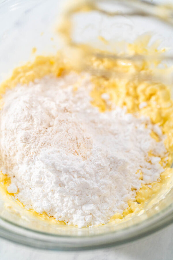 Mixing ingredients in a large glass mixing bowl to make the cream cheese filling for bundt cake.