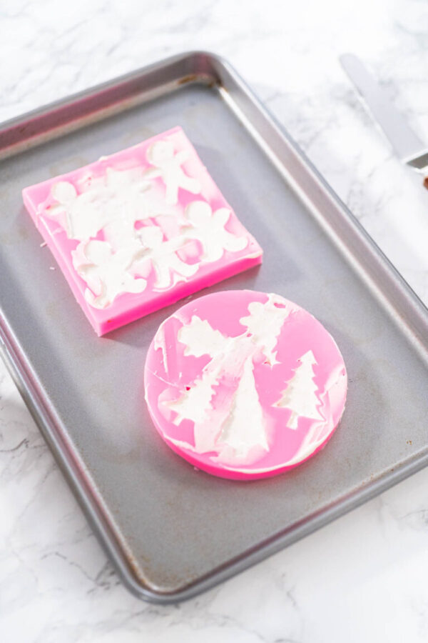 Filling silicone mold with white melted chocolate to make a chocolate gingerbread man.