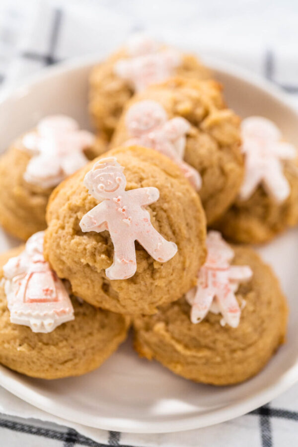 Eggnog cookies with a chocolate gingerbread man on a white plate.