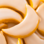 Stack of lemon wedge cookies with glaze for gifting.