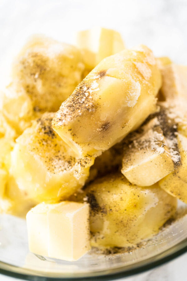 Mashed potatoes. Mashing cooked potatoes in a glass mixing bowl with a potato masher to make mashed potatoes.