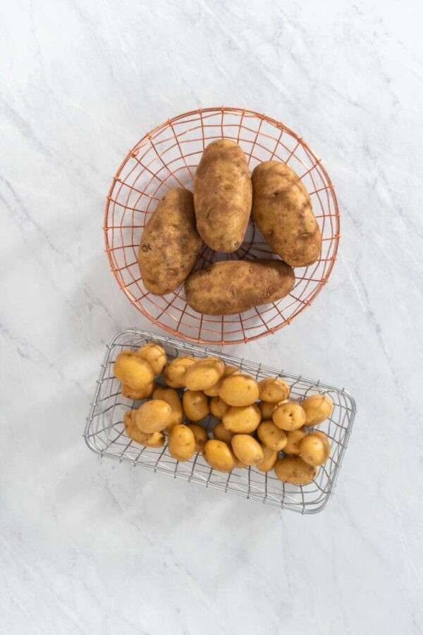 Flat lay. Pressure Cooker Baked Potatoes. Raw potatoes in a wire basket on the kitchen counter.