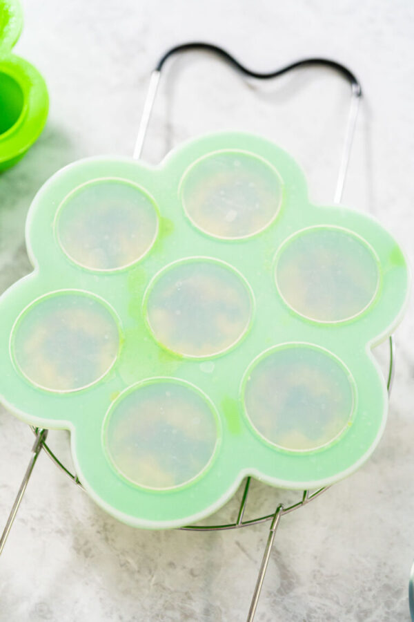 Filling silicone molds with egg mixture to make egg bites in a pressure cooker.