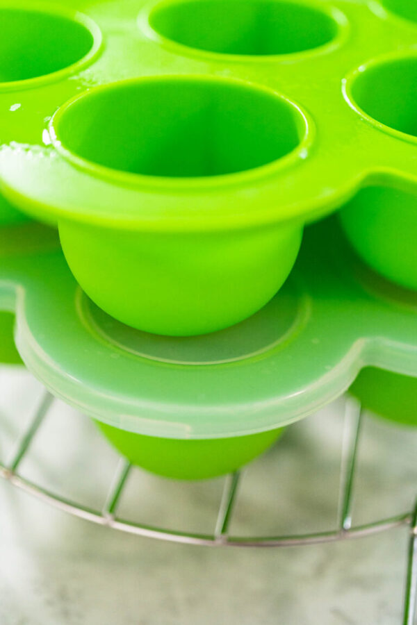 Filling silicone molds with egg mixture to make egg bites in a pressure cooker.