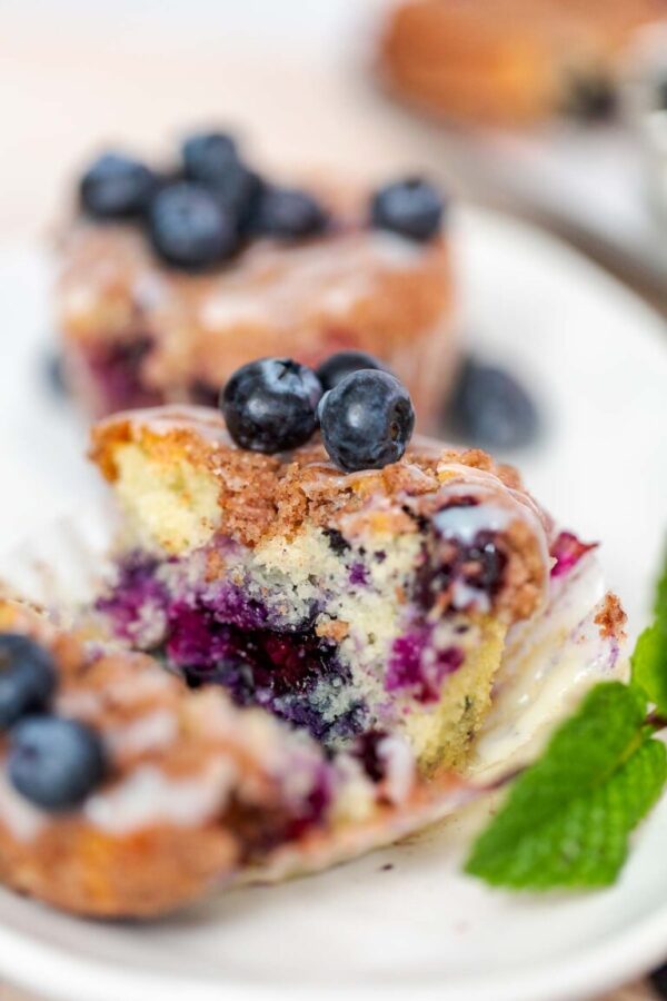 Sliced homemade blueberry muffins on a white plate.