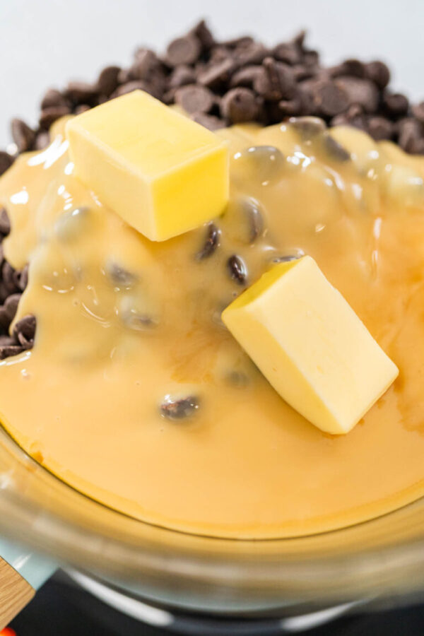 Melting white chocolate chips and other ingredients in the double boiler to prepare Christmas cookie-cutter peppermint fudge.