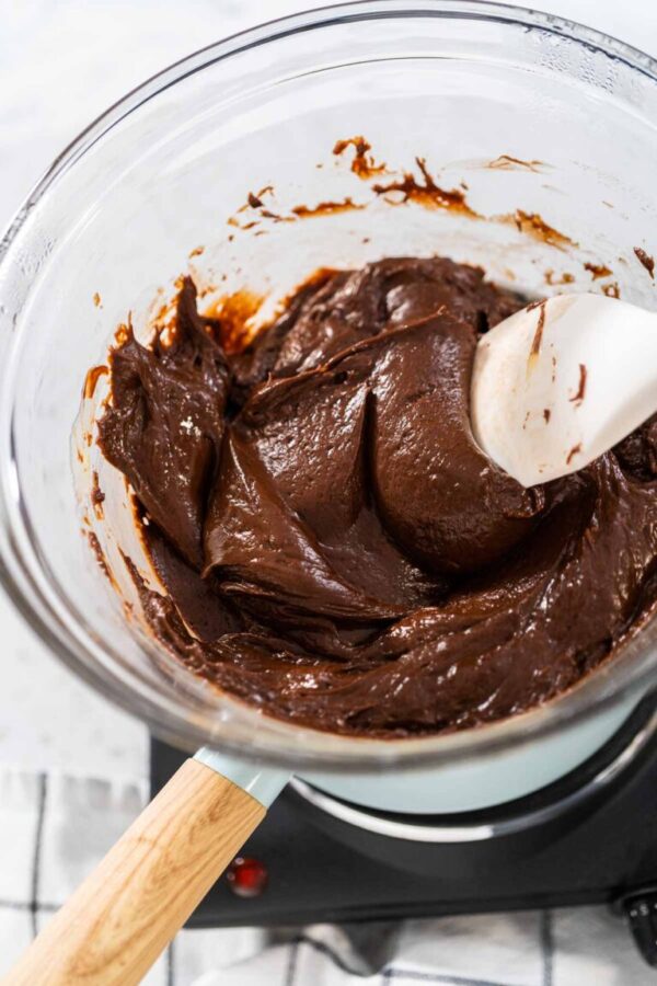 Melting white chocolate chips and other ingredients in the double boiler to prepare Christmas cookie-cutter peppermint fudge.