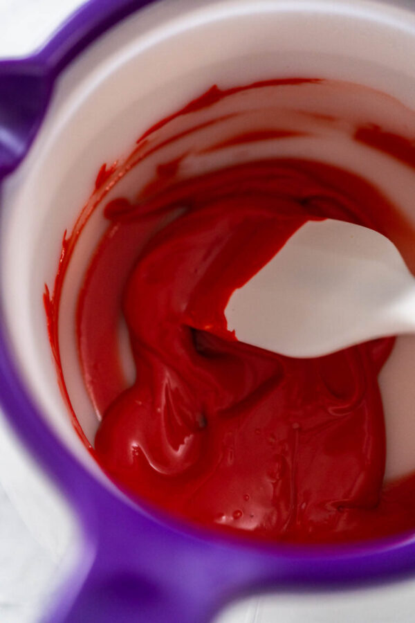 Melting red chocolate chips in a candy melting pot to make chocolate hearts for decorating green fudge.
