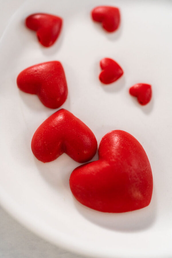 Removing chocolate hearts from silicone mold to decorate green fudge.