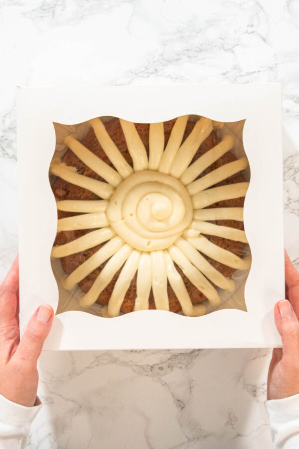 The Carrot Bundt Cake is carefully packaged into a white paper bundt cake box, ready for gifting or sharing.