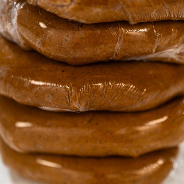 Classic Gingerbread Cookie Dough for Holiday Baking - Arina Photography Discs of Classic Gingerbread Cookie Dough are stacked and wrapped in plastic, ready for chilling before being rolled out. Chilling helps the dough hold its shape, making it easier to cut into festive cookies.