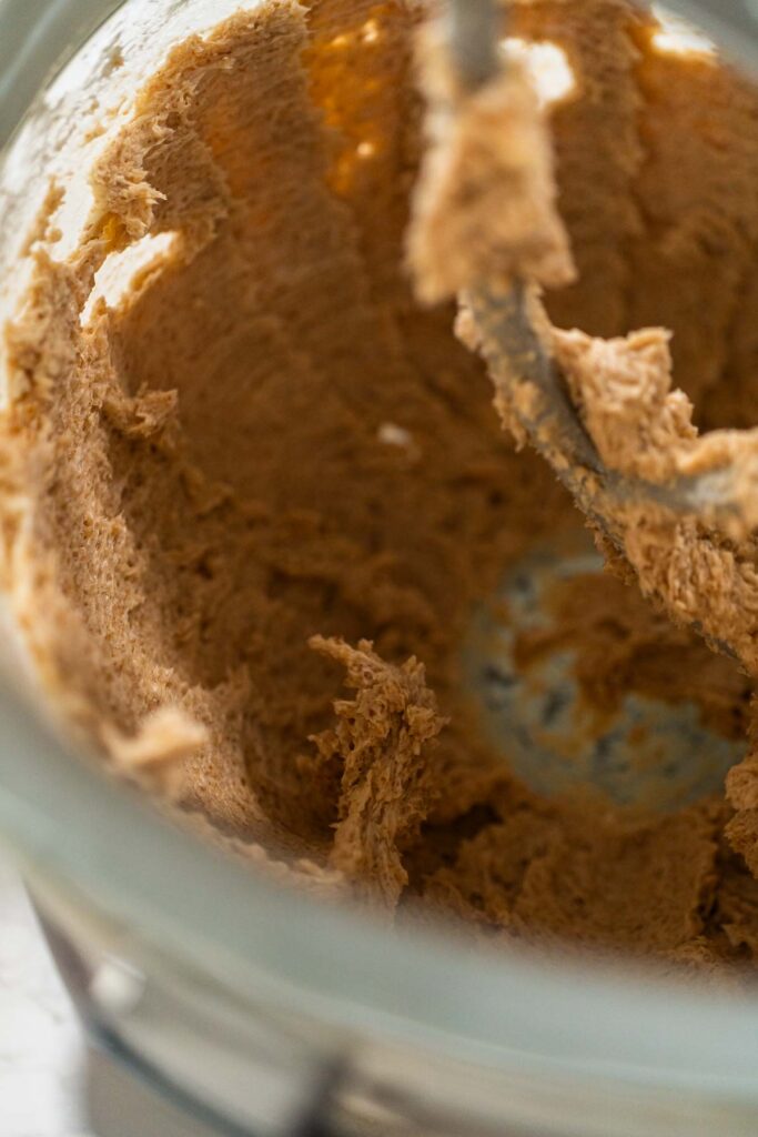The butter and brown sugar mixture in the stand mixer, ready for creaming. This step will blend the ingredients until they are light and fluffy, forming the base of the dough.