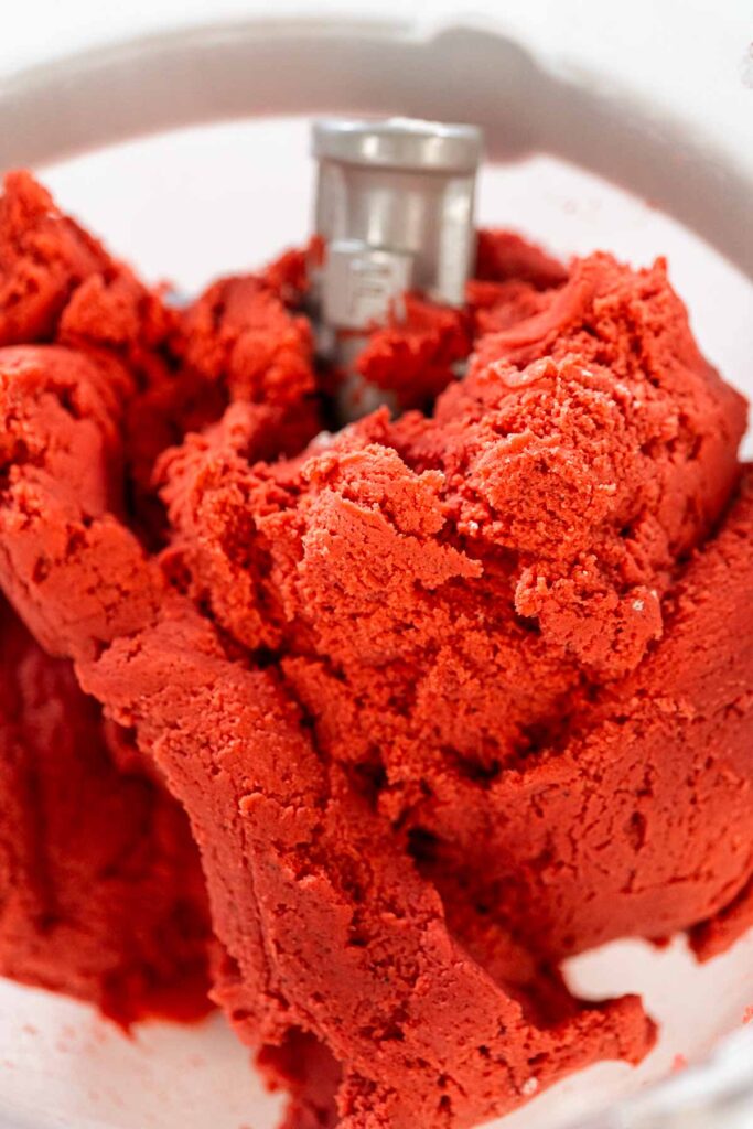 The finished Classic Red Gingerbread Dough is shown in the mixing bowl, ready to be divided. The dough’s striking red color and smooth consistency indicate it is prepared for chilling.