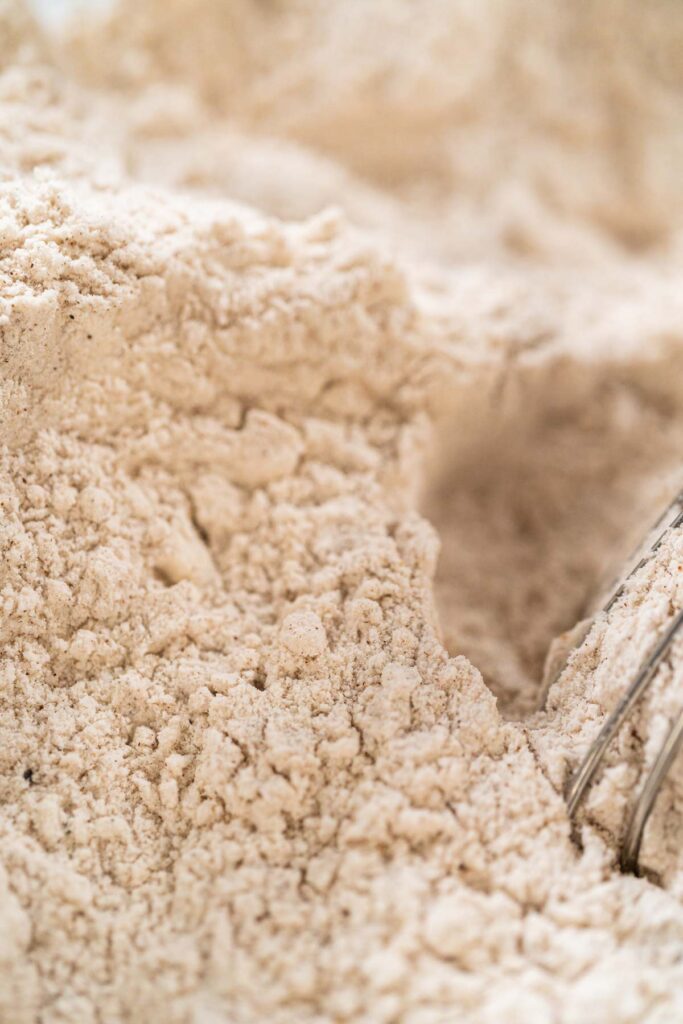 Top-down view of dry ingredients for Spiced Gingerbread Cookie Dough Perfect for Baking being whisked in a glass bowl. The flour and spices are mixed together, creating a uniform blend for the gingerbread dough.