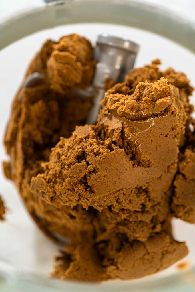 Final stage of mixing in the stand mixer, with the Spiced Gingerbread Cookie Dough Perfect for Baking fully combined and smooth, ready for shaping. The dough has a rich, dark color, ideal for holiday cookies.