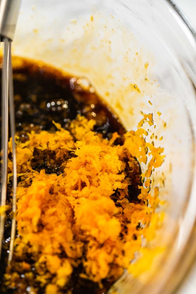 Orange zest added to the molasses and egg mixture for Zesty Orange Gingerbread Cookie Dough. The bright orange zest introduces a refreshing citrus note to balance the deep flavors of molasses.