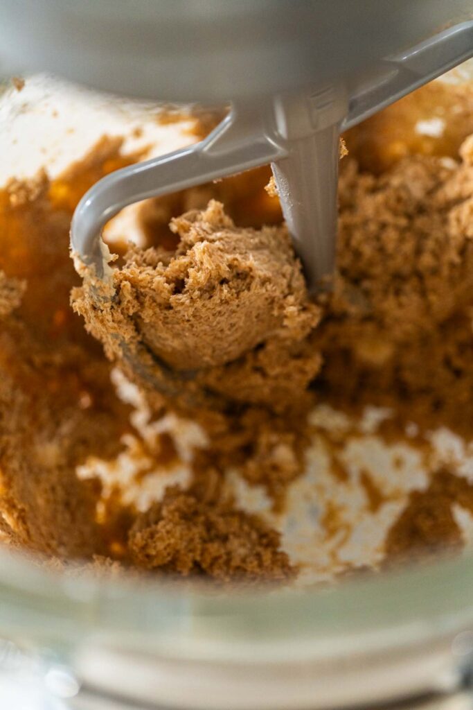 Creaming butter and brown sugar together in a mixer for Chocolate Gingerbread Cookie Dough. This step ensures a smooth, fluffy base for the dough, enhancing its texture and flavor.