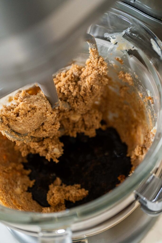 Adding the molasses and egg mixture into the creamed butter and sugar in preparation for Chocolate Gingerbread Cookie Dough. This dark, rich molasses will give the dough a deep flavor and color.