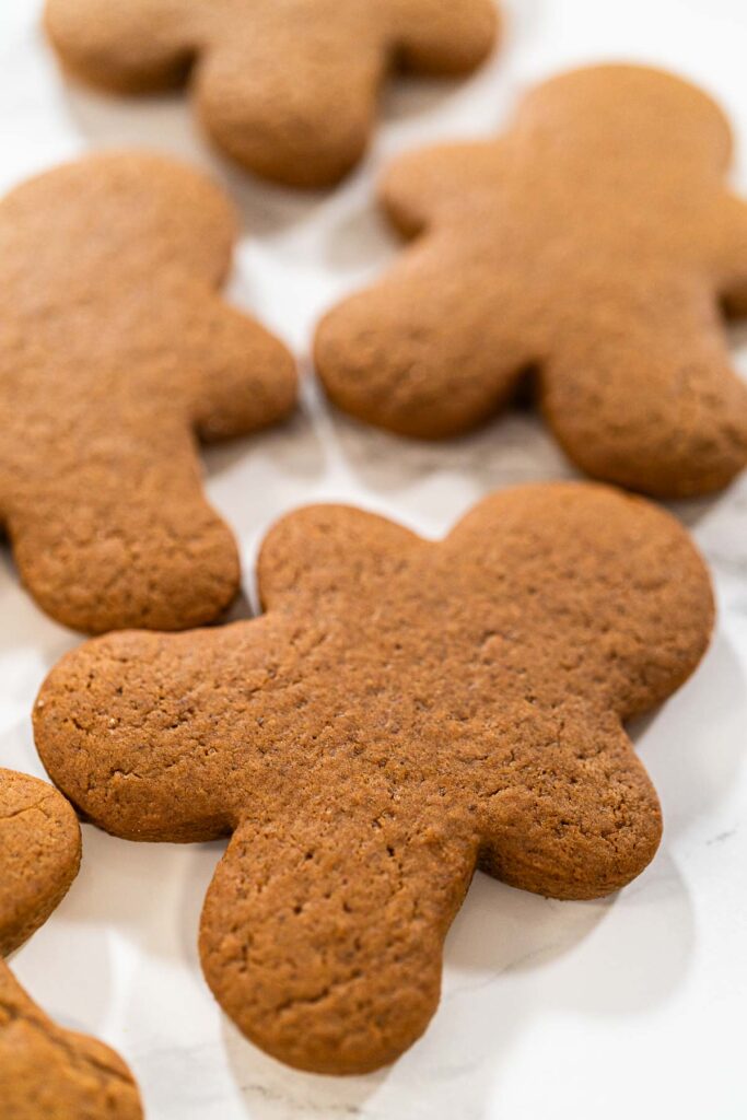 Step-by-Step Process of Making Spiced Gingerbread Cookies - Arina Photography Cluster of baked Spiced Gingerbread Cookies arranged on a marble surface, highlighting their festive appearance and holiday appeal.