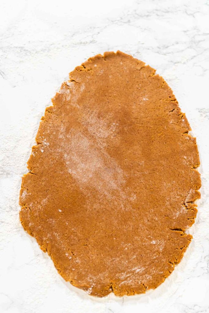 The dough for Orange Zest Gingerbread Cookies is rolled out smoothly, ready for cutting shapes. The image highlights the smooth texture from a straight-on perspective.