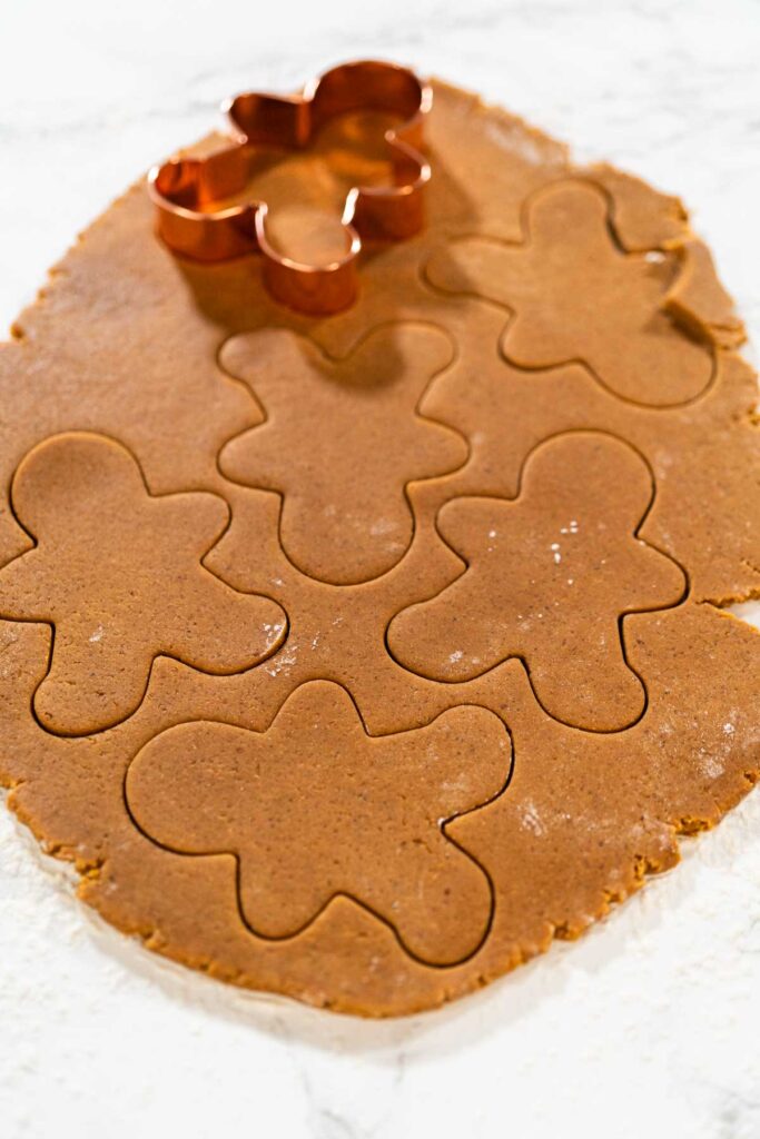 Preparing and Baking Classic Gingerbread Cookies in Gingerbread - Arina Photography Close-up of a cookie cutter pressing into gingerbread dough on a floured surface.