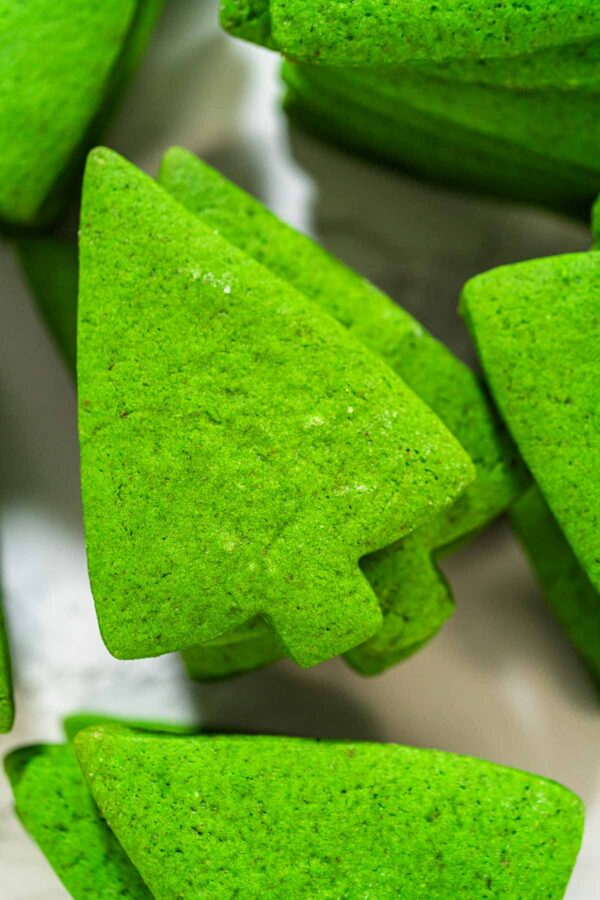 Close-up of vibrant green Christmas tree-shaped sugar cookies made from tinted dough, perfect for holiday decorating and gifting – featured in the How to Decorate Christmas Tree Cookies recipe.